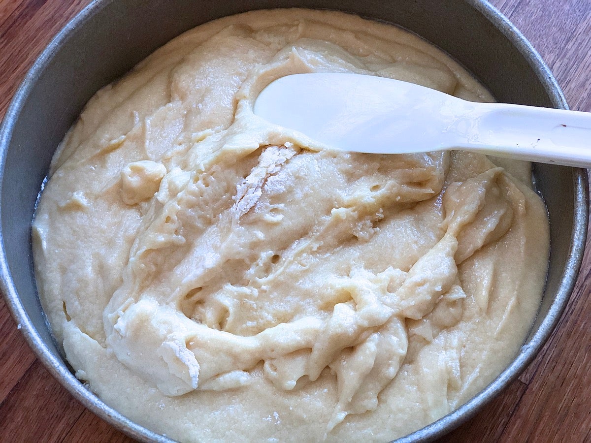 Lumpy, poorly mixed cake batter scooped into an 8" round cake pan.