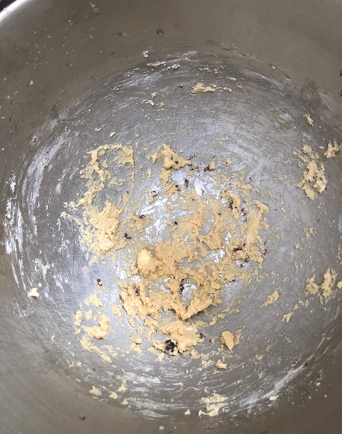 Nearly empty mixing bowl, small amount of dough left in the bowl.