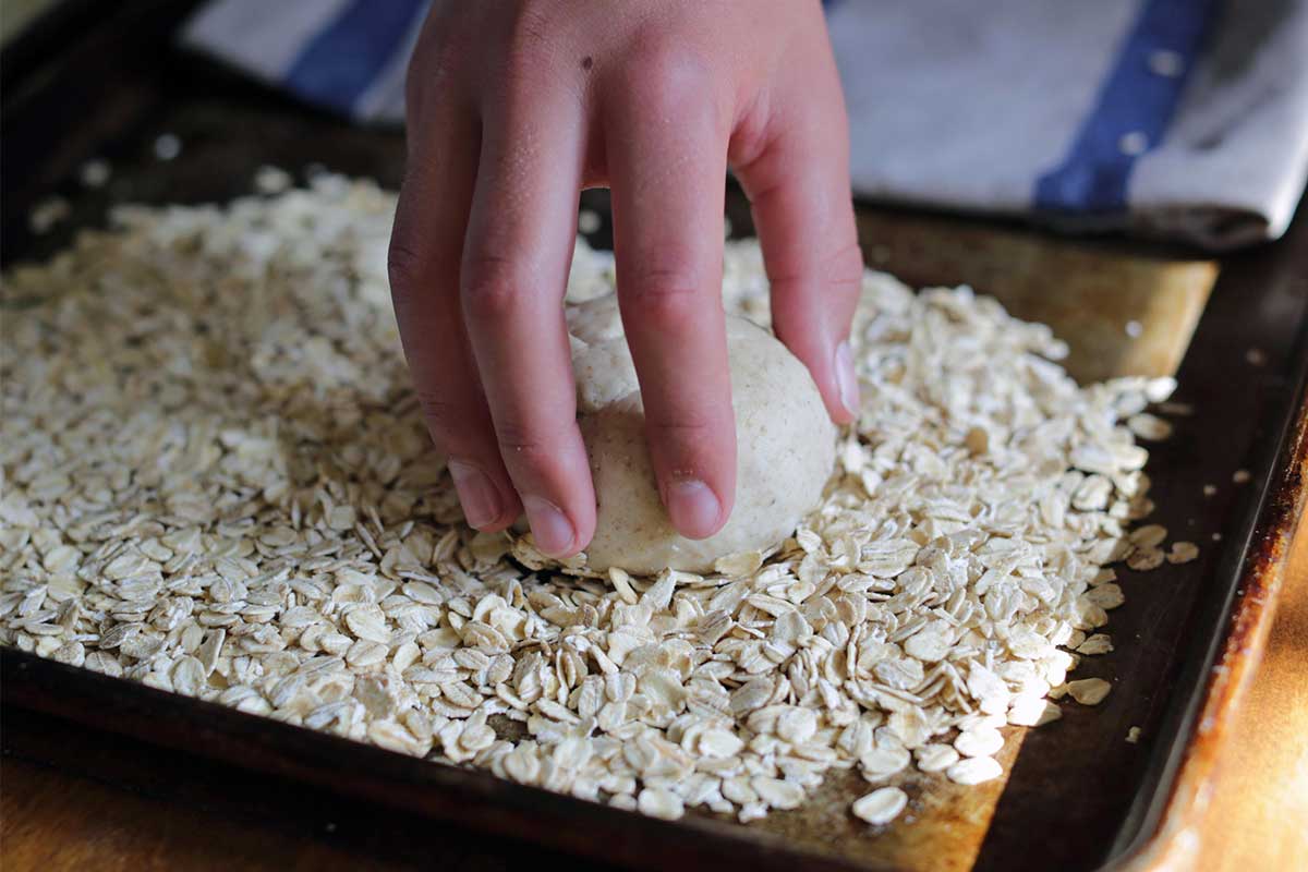 Placing moistened unbaked roll on seed tray