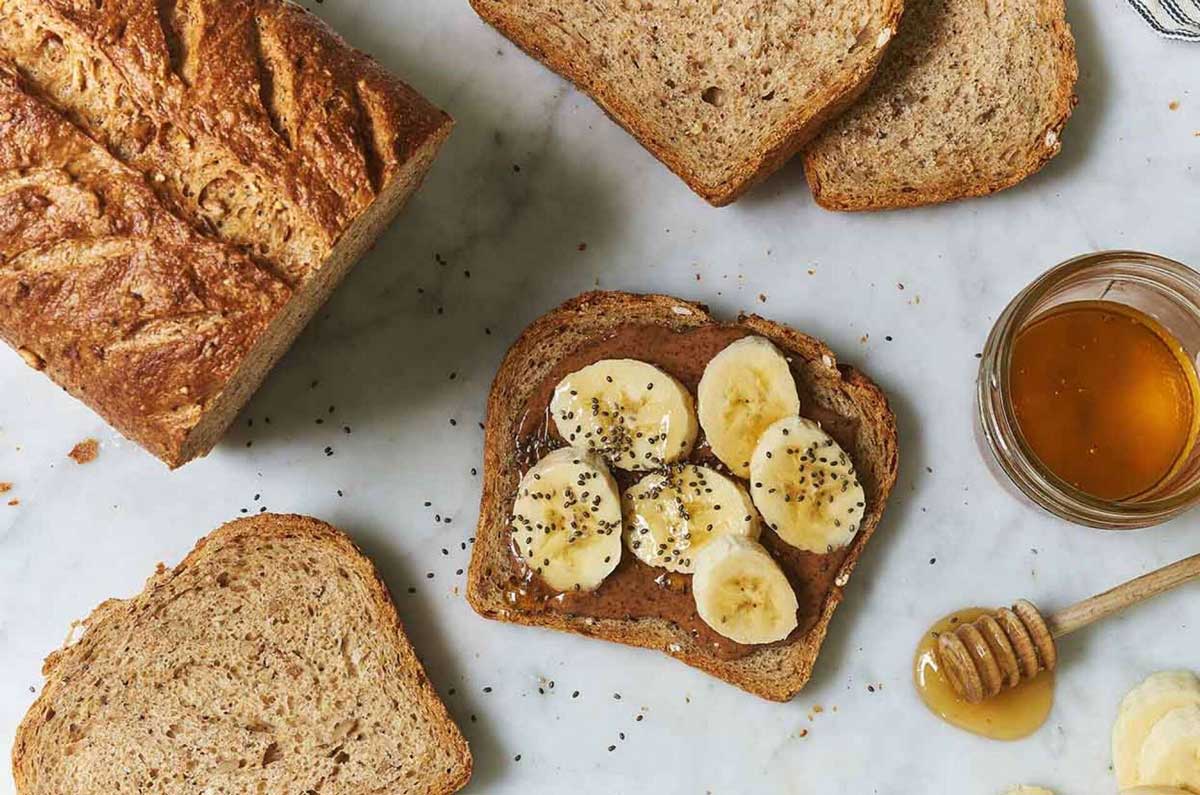 Slice of seeded multigrain sourdough topped with honey and banana slices