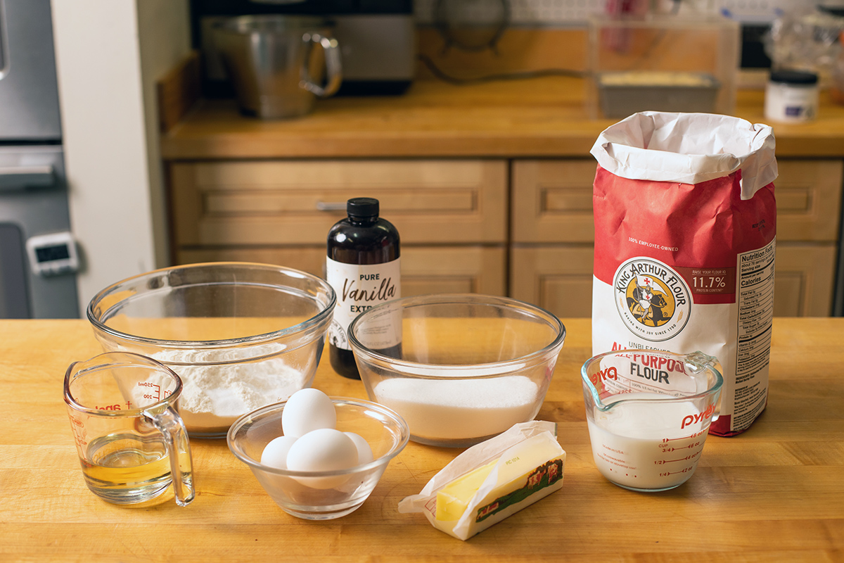 All of the ingredients needed to make the Classic Birthday Cake on a table in the test kitchen: eggs, flour, butter, sugar, etc.