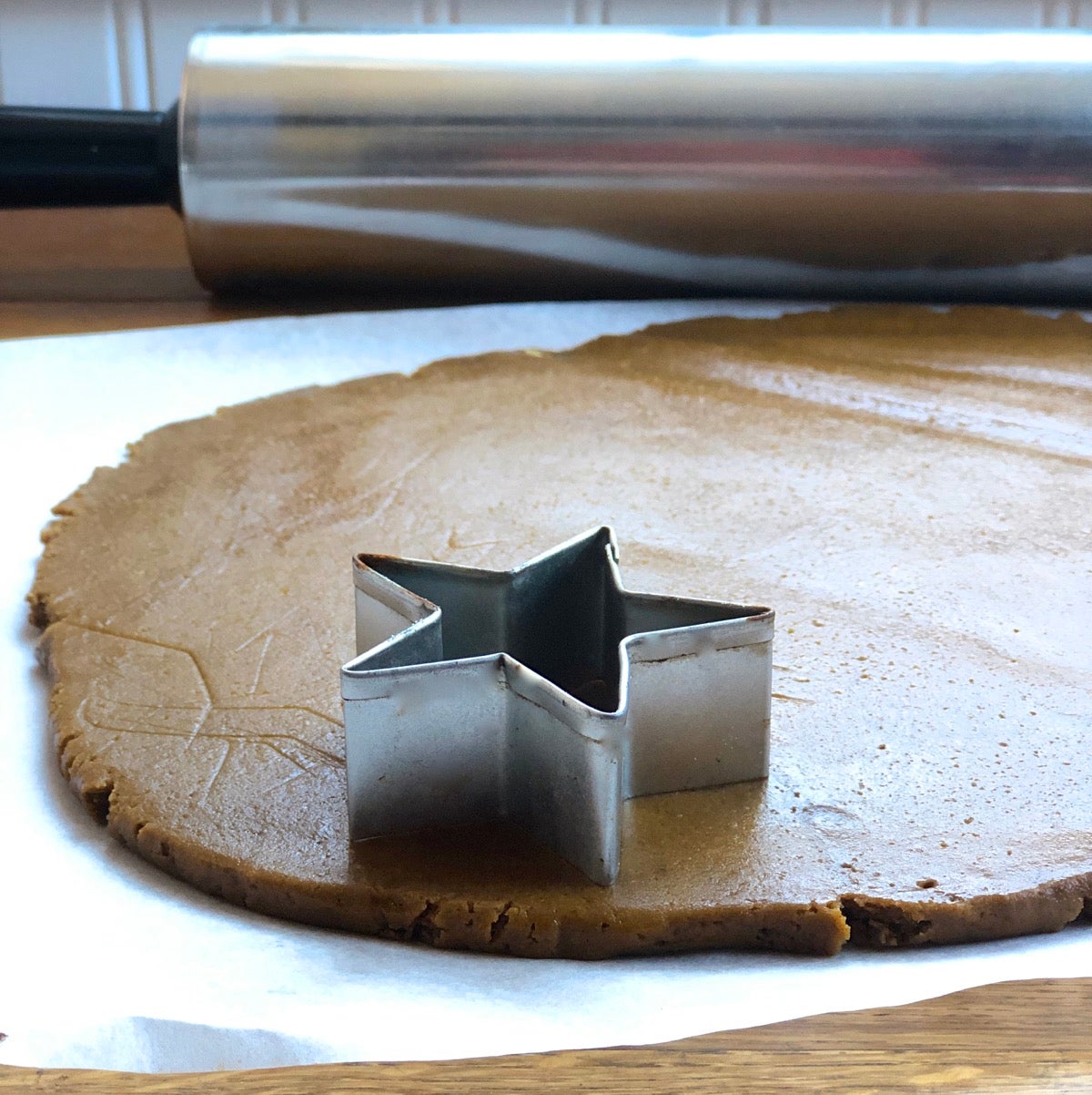 Rolled out gingerbread dough showing its thickness, with a star cookie cutter.