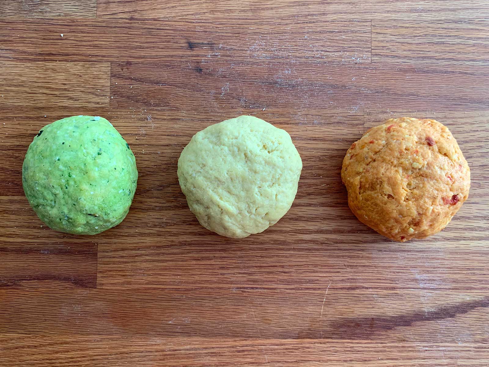 Three different doughs in green, plain, and orange