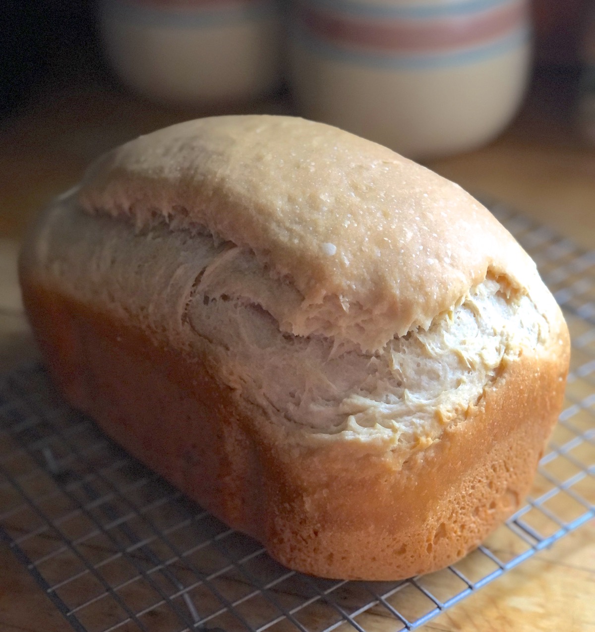 Loaf of sourdough sandwich bread on a cooling rack