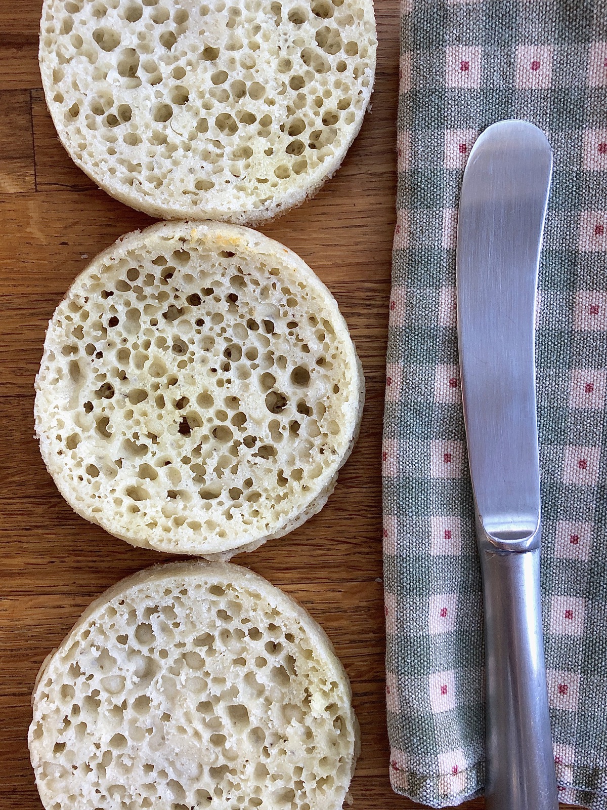 Three sourdough crumpets, split to show their hole-riddled interior.
