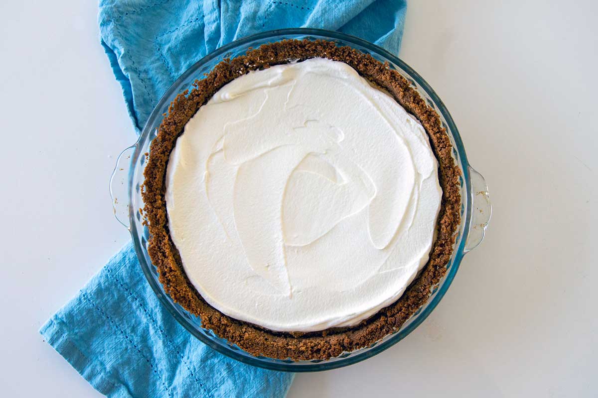 Cheesecake with whipped cream spread evenly across the surface