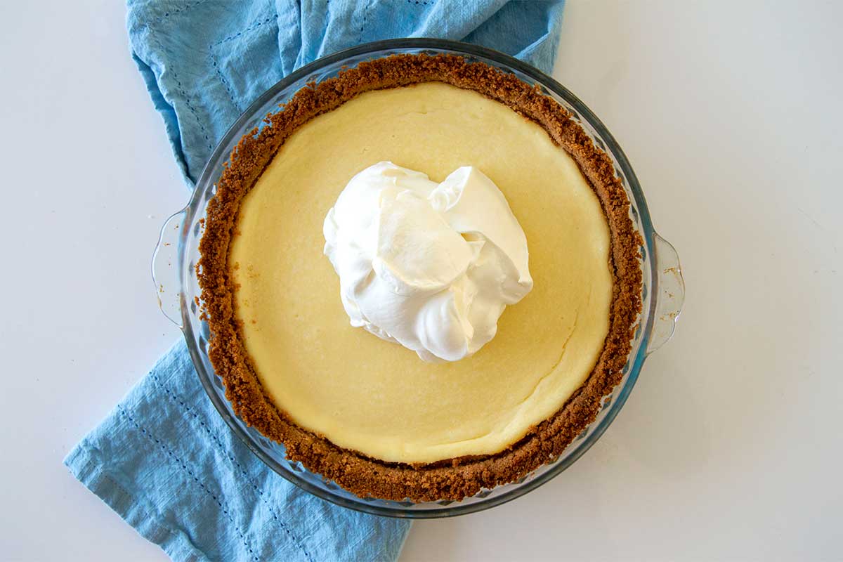 Cheesecake with a mound of whipped cream scooped on top