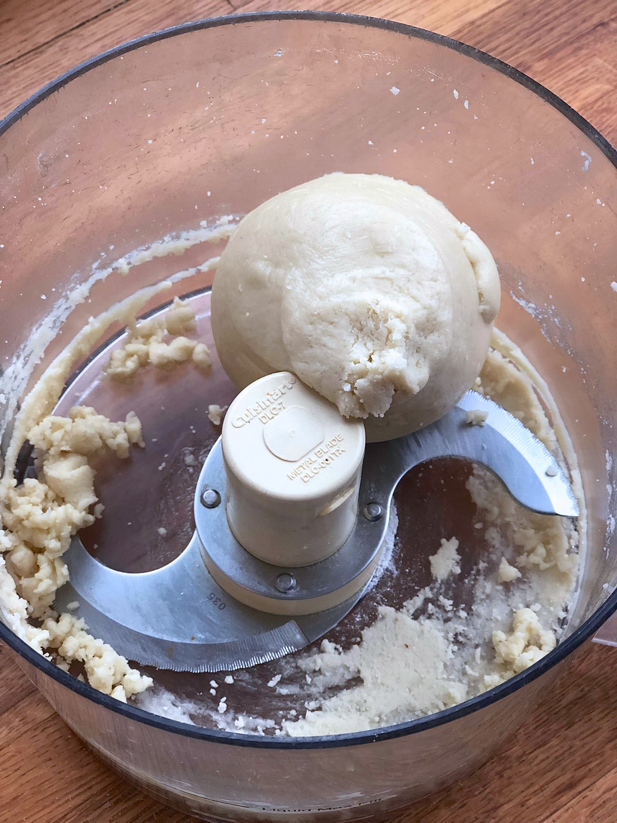 Fresh-made almond paste in the work bowl of a food processor.