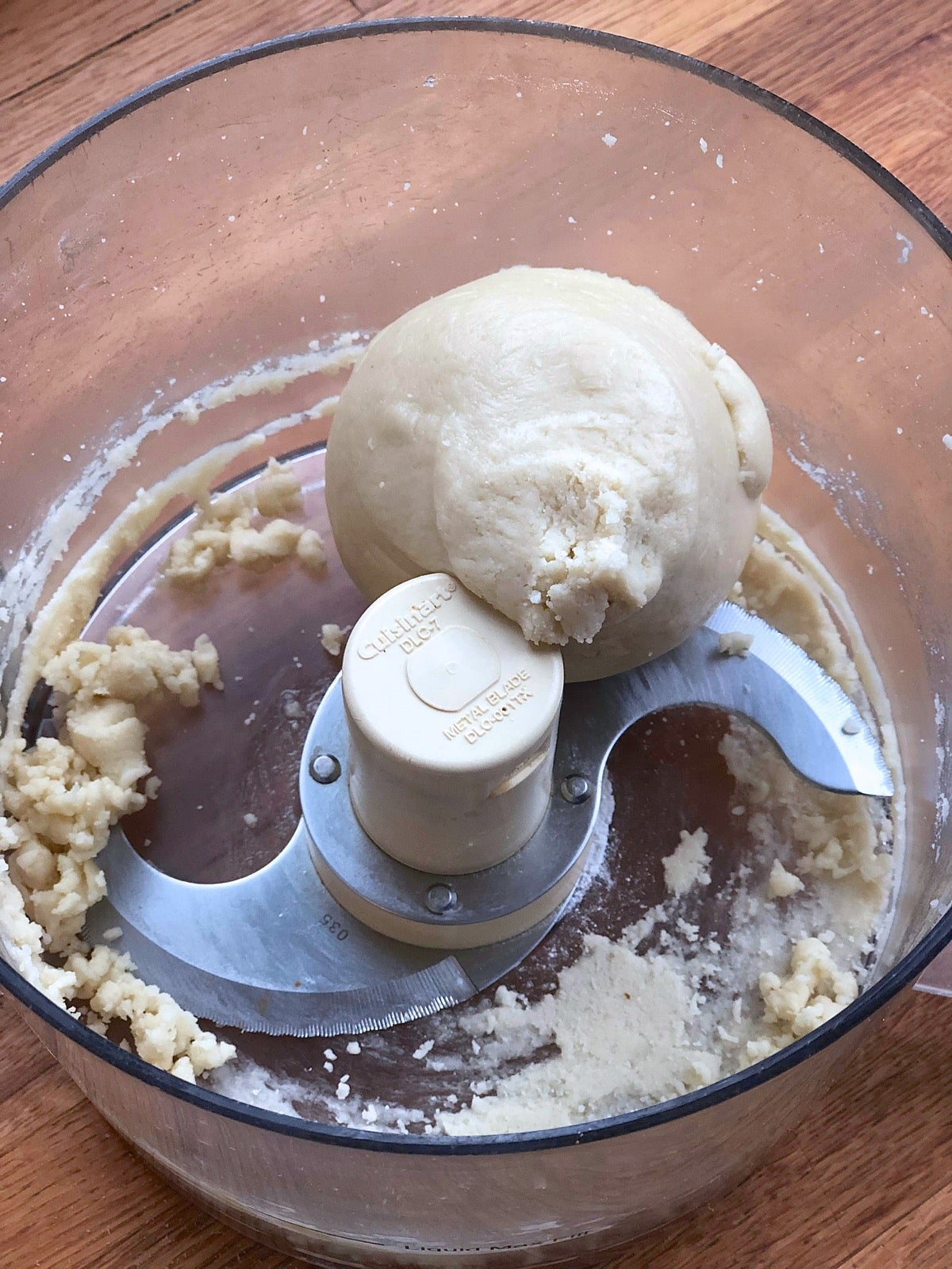 Fresh-made almond paste in the work bowl of a food processor.