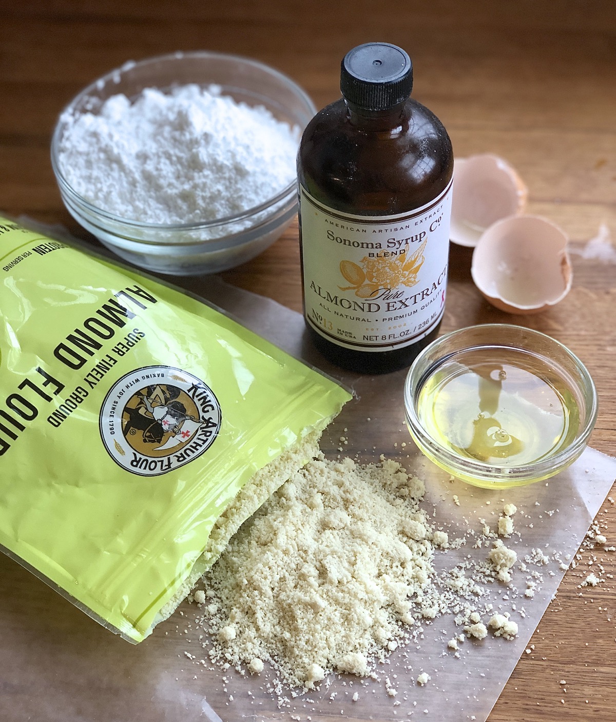 Ingredients for homemade almond paste: almond flour, confectioners' sugar, egg white, and almond extract.