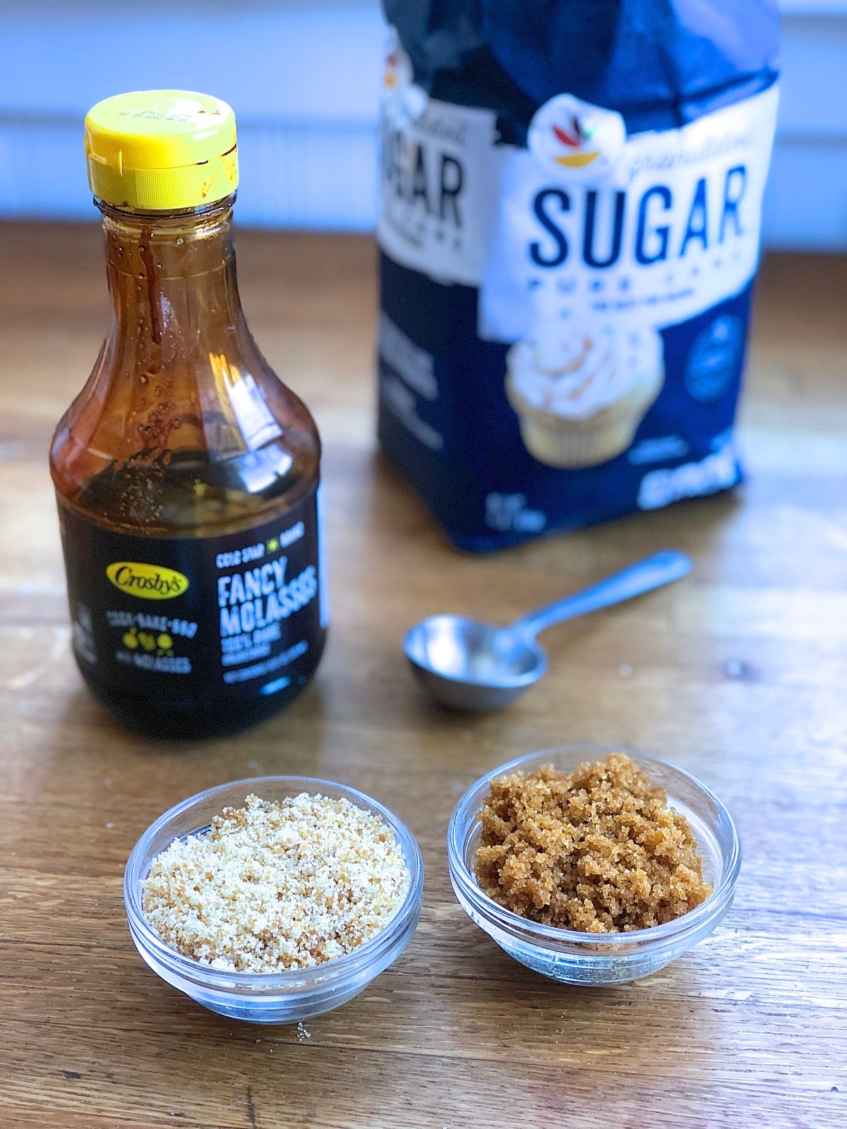 Small bowls of white sugar to which molasses has been added, showing how to make brown sugar from white sugar.