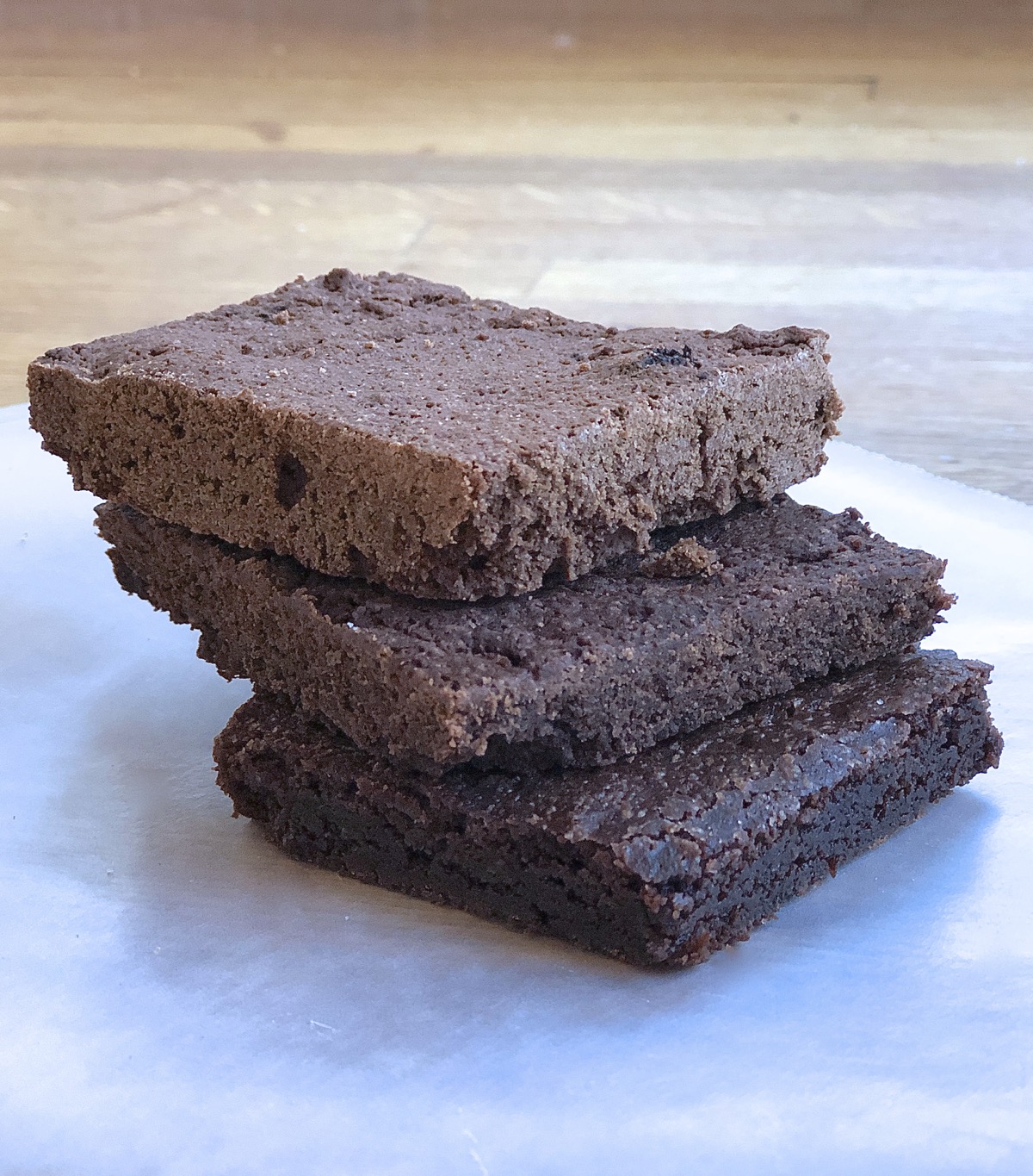 Brownie squares stacked atop one another showing different textures: one made with Truvia, one made with Swerve, one made with granulated sugar.