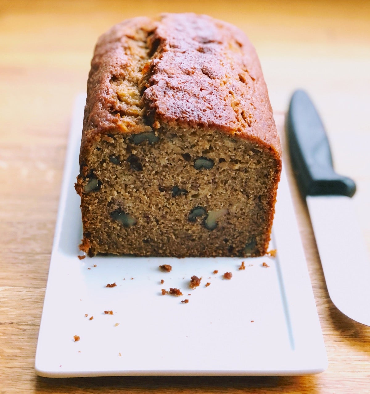 Banana bread on a plate, end sliced off so you can see the interior.