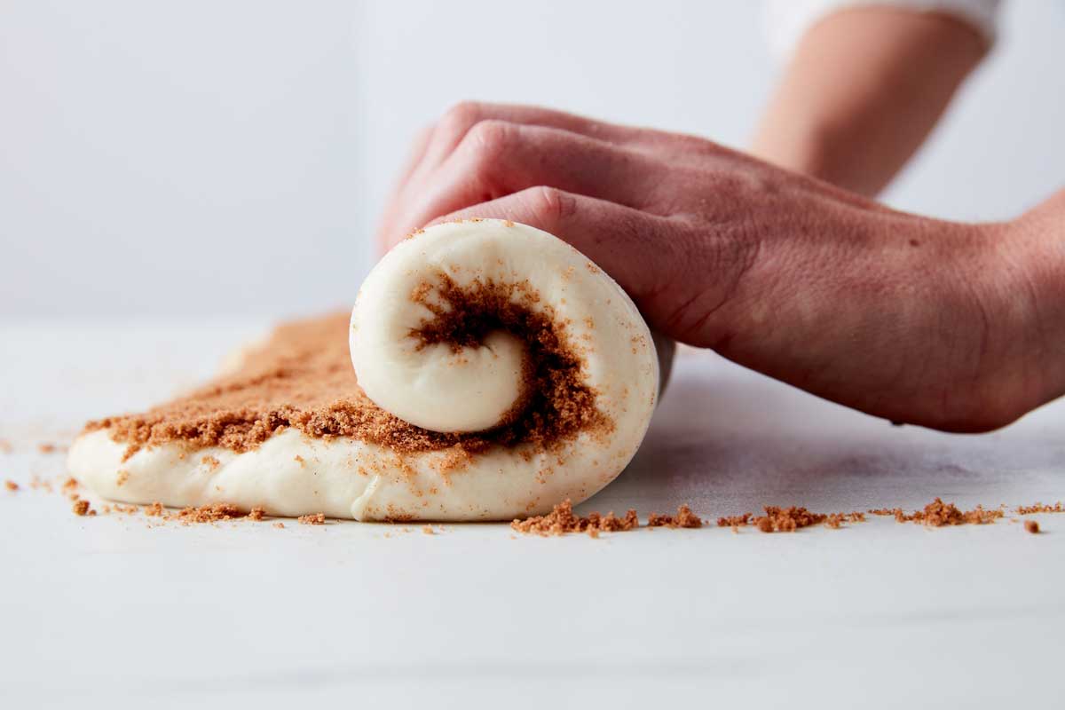 Cinnamon roll dough being rolled up