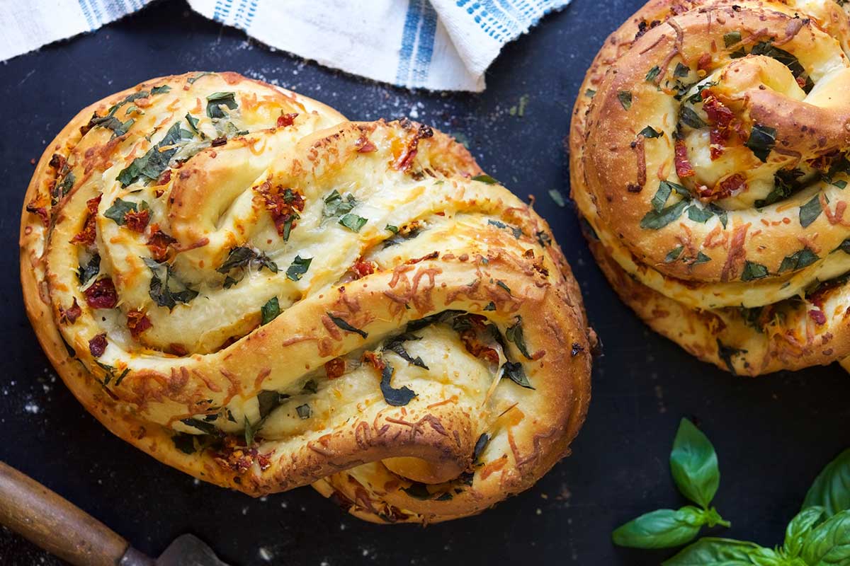 A swirled Pane Bianco loaf of bread filled with tomato, basil, and garlic