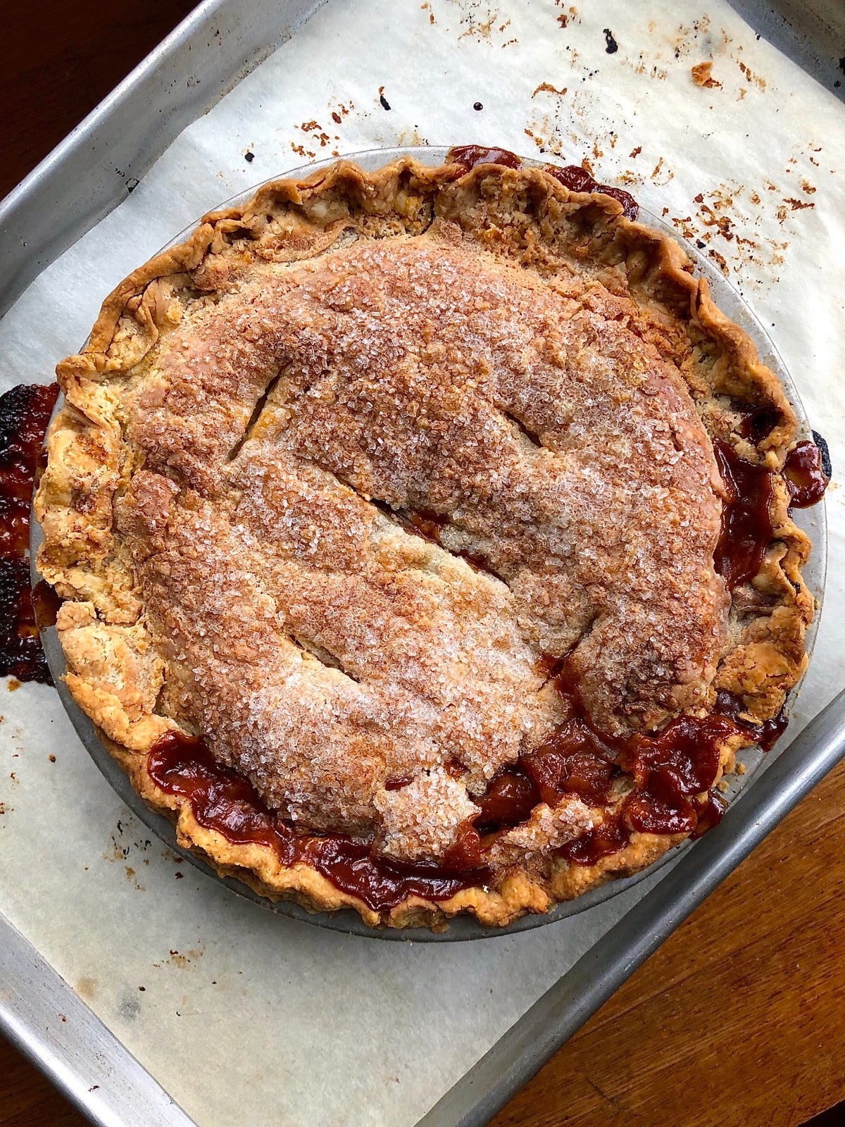 Baked apple pie on a parchment-lined baking sheet.