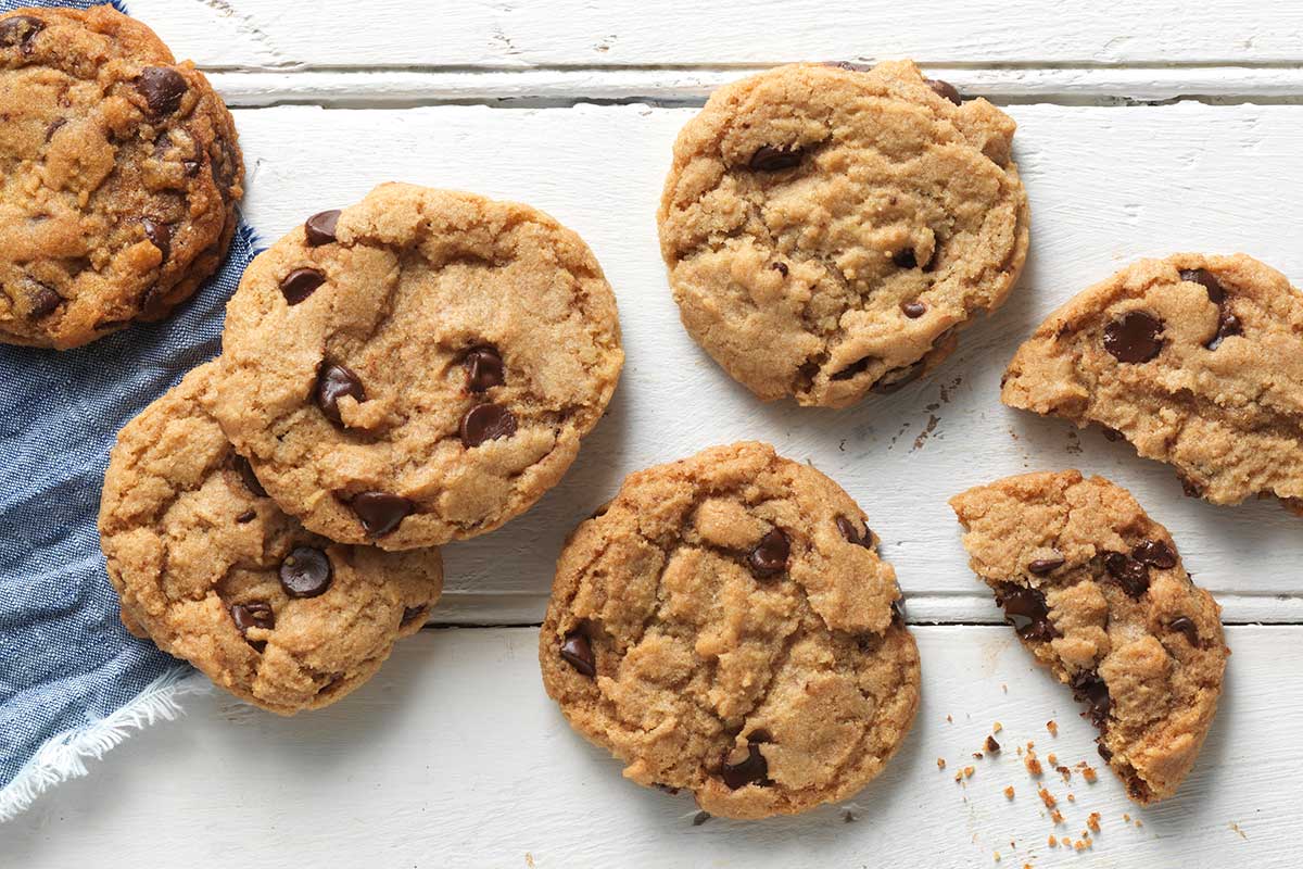 A pile of vegan chocolate chip cookies on a kitchen counter