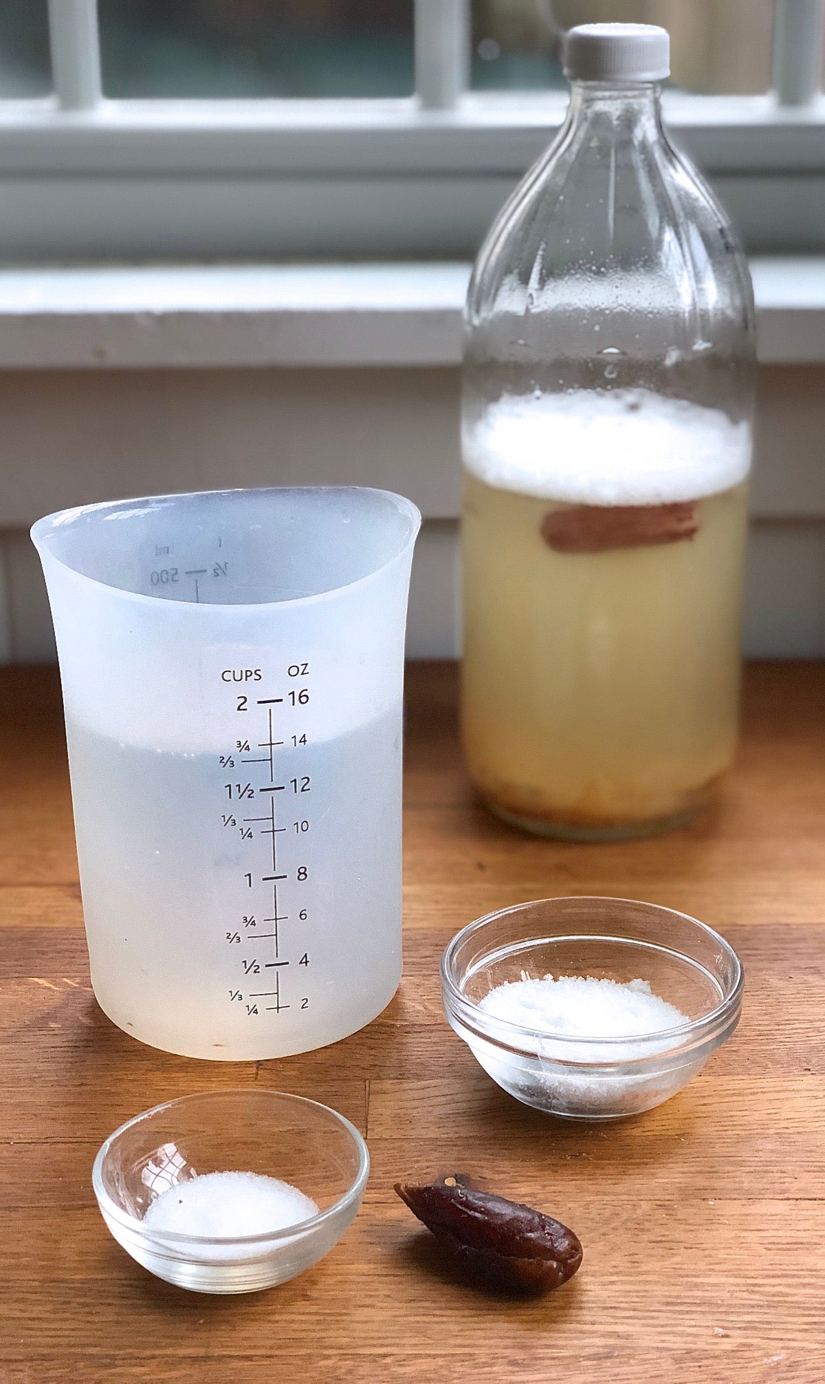 Yeast water ready to be fed with salt, sugar, and another dried date.