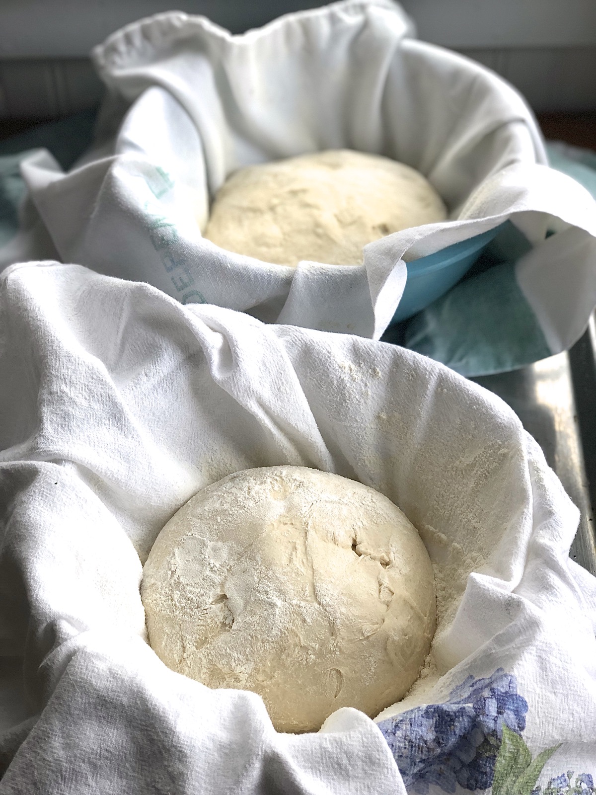 Shaped dough in a towel-lined bowl, ready to rise.