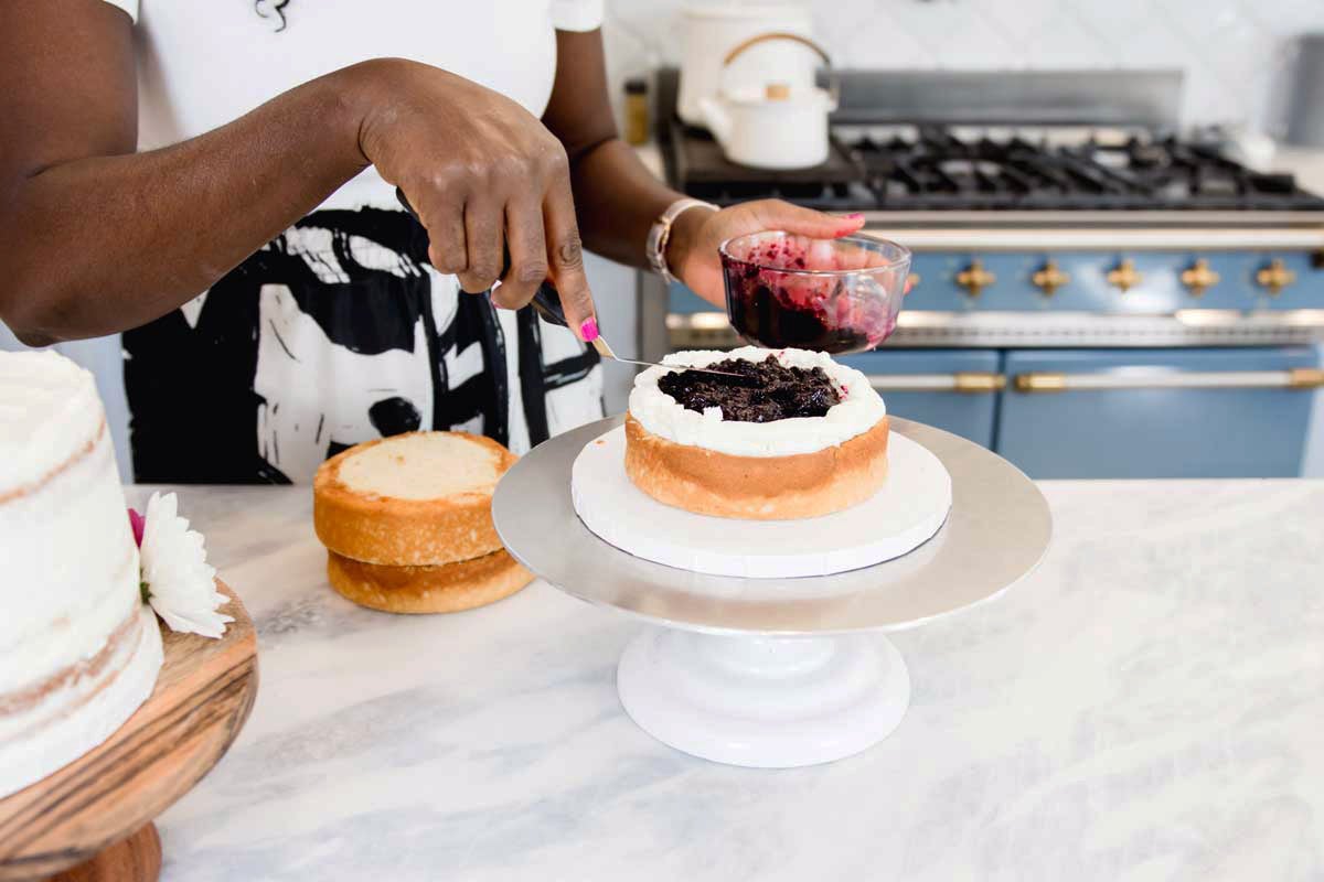 Zainab smoothing filling onto cake layer