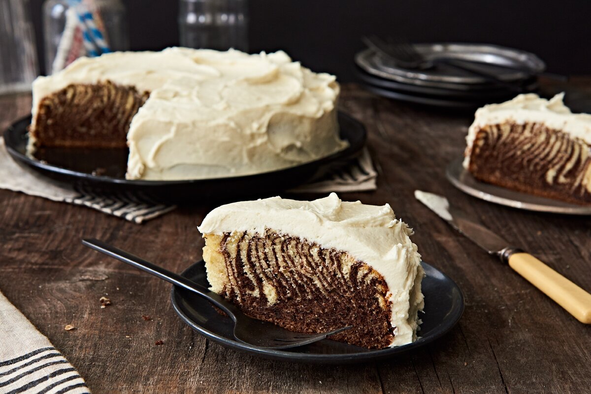 A slice of a zebra cake, showing off alternating layers of chocolate and vanilla batter