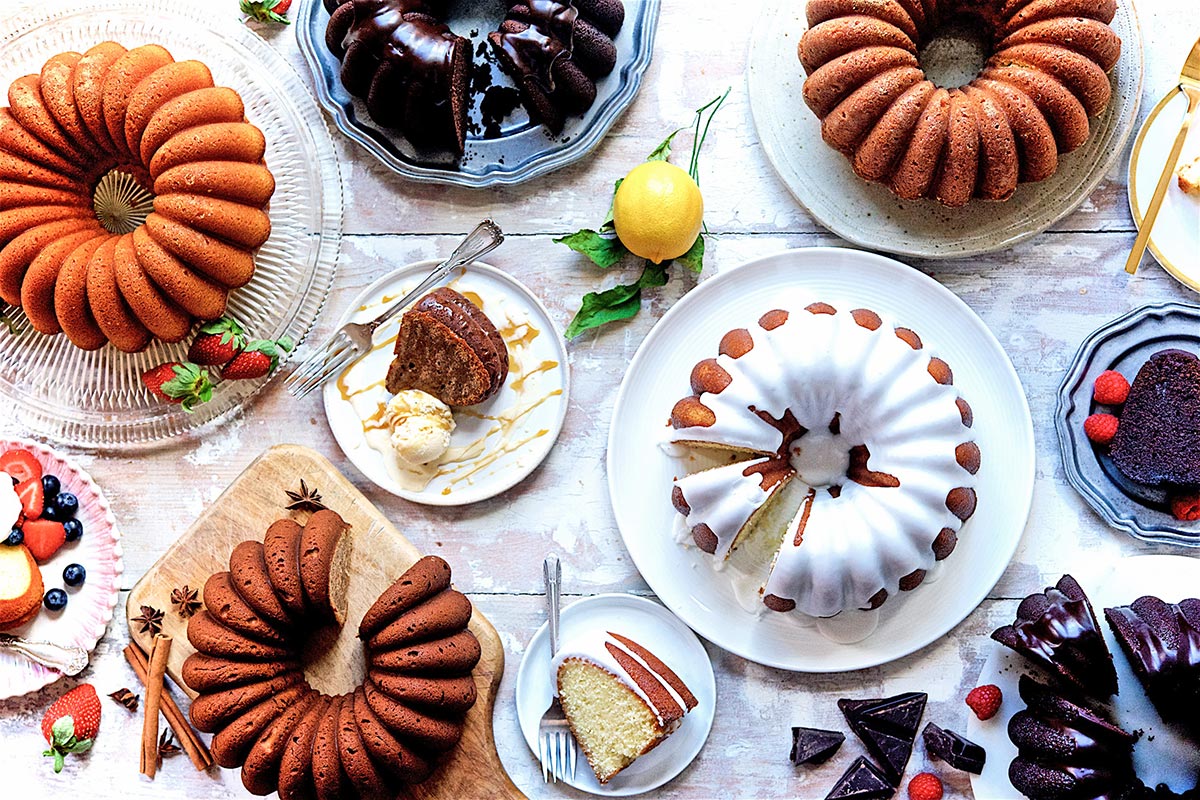 A table covered with a spread of different Bundt cakes