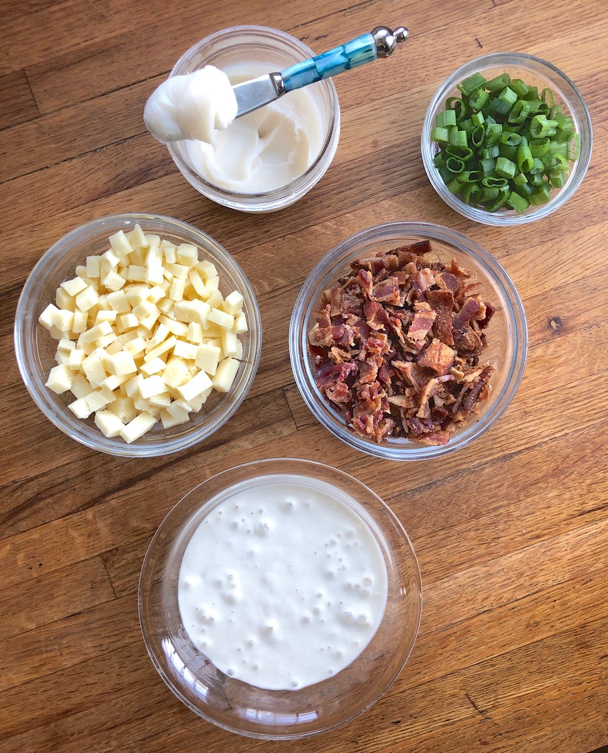 Ingredients for bacon-cheddar-onion grits on a cutting board.