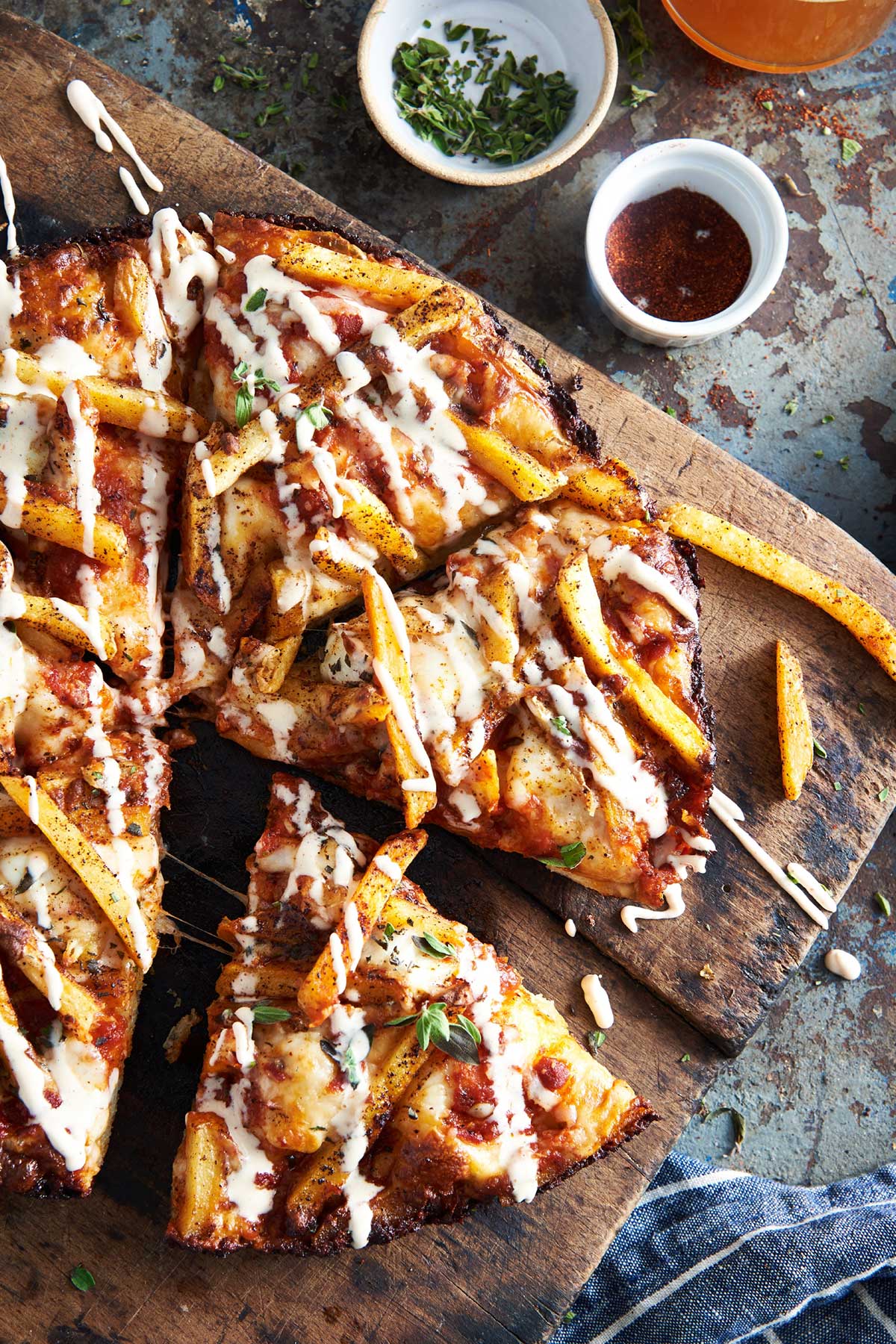 Crispy Cheesy Pan Pizza in a cast iron pan topped with french fries, chili and ranch dressing