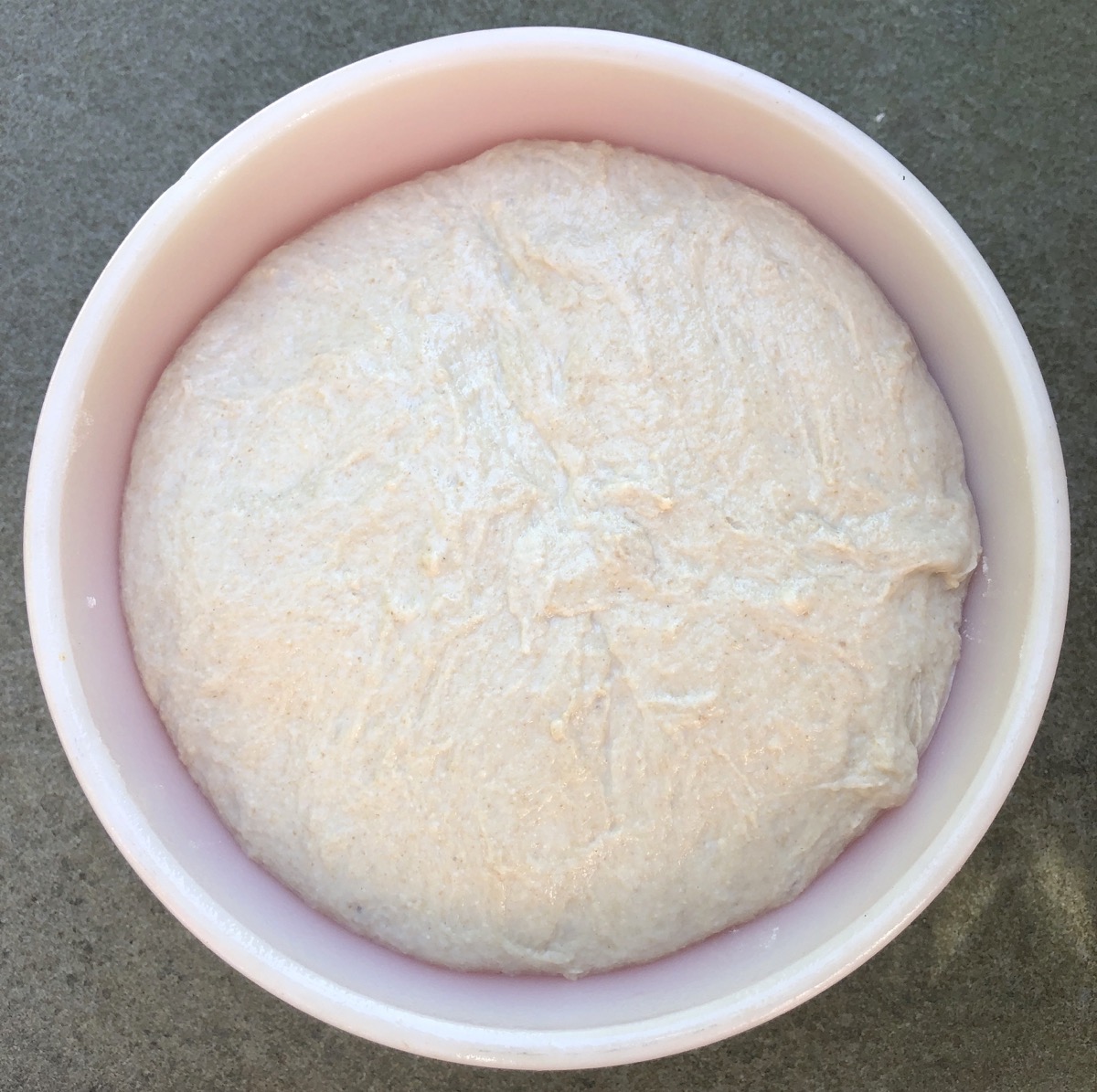 Risen dough in a Pyrex bowl.