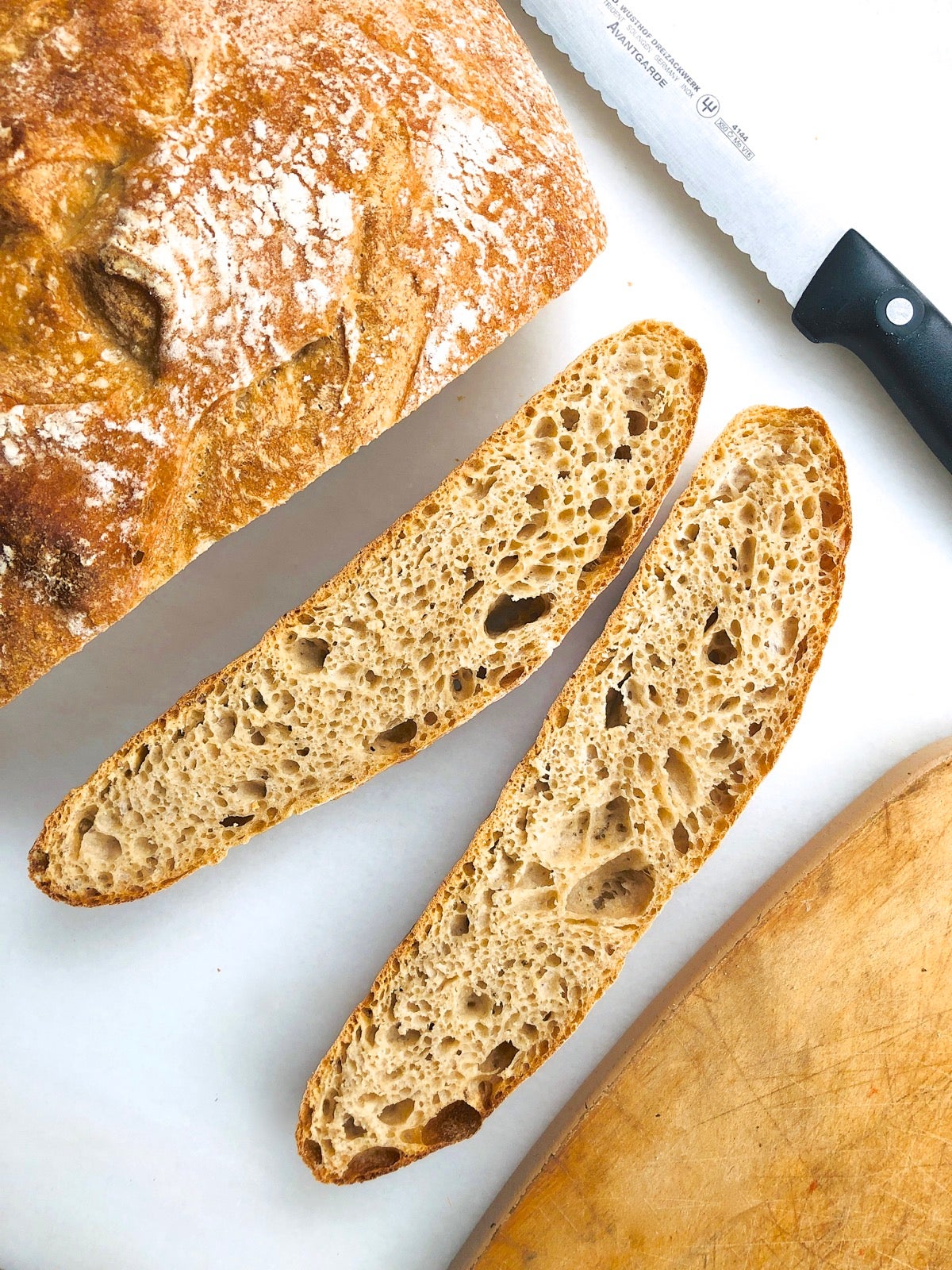 Sourdough bread on a marble slab, two slices cut.