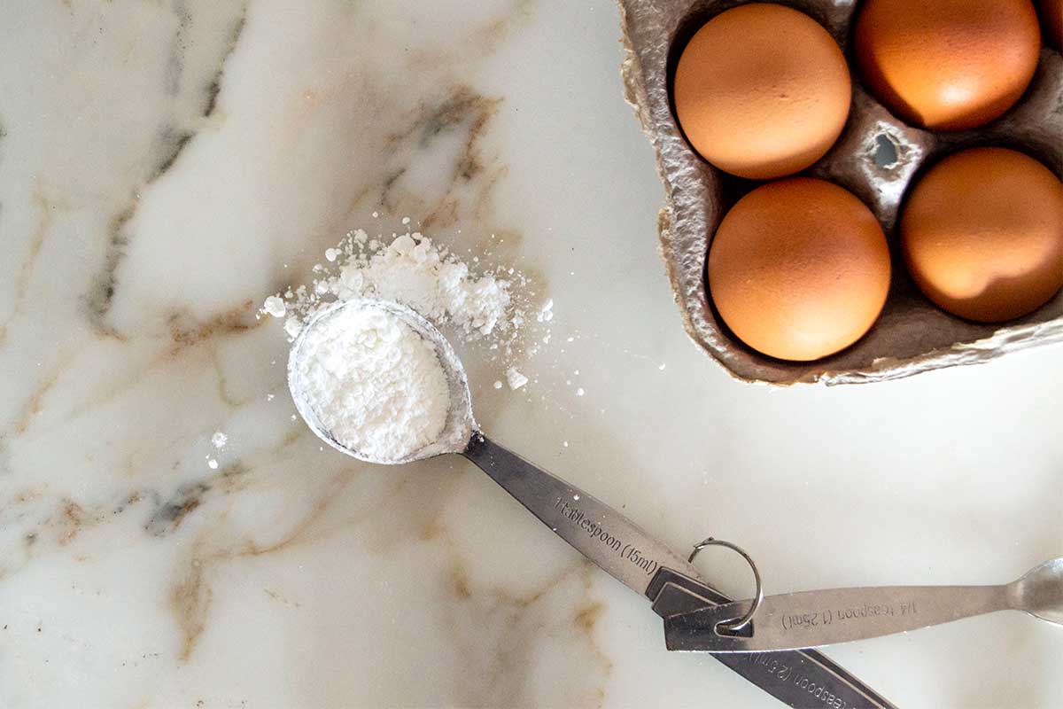 Spoonful of cornstarch next to eggs