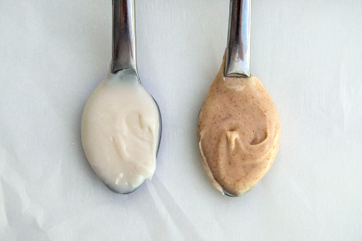 Spoonful of regular icing next to spoon of cinnamon icing