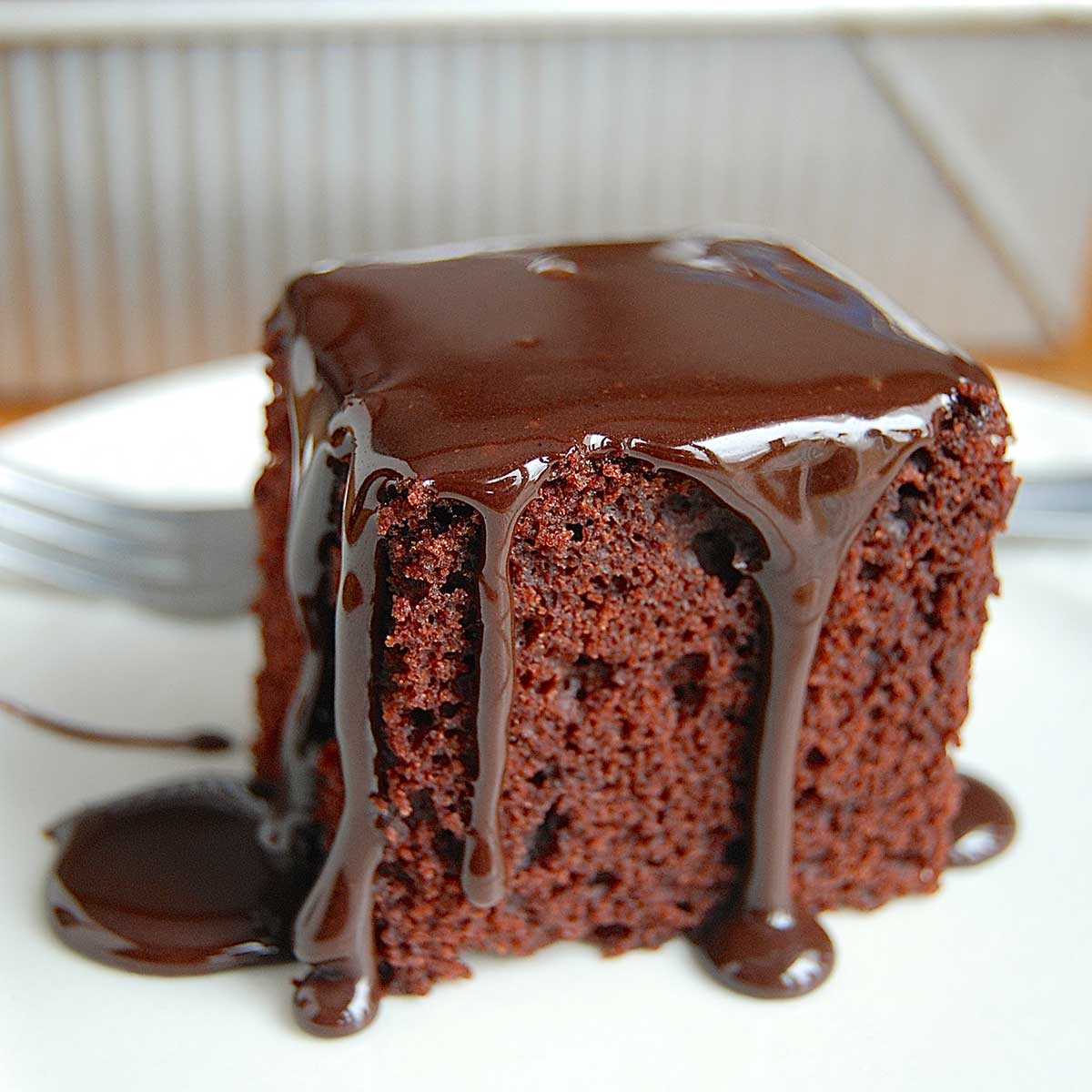 A slice of gluten-free cake pan cake on a plate topped with frosting