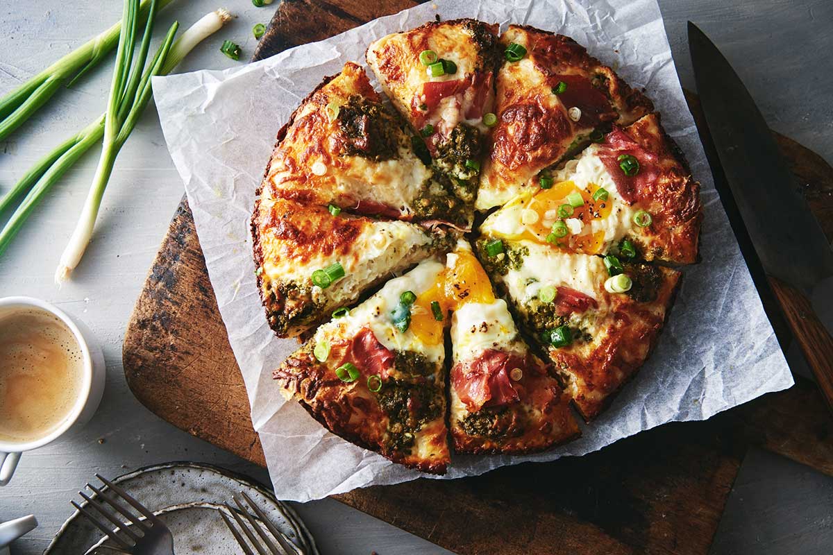 Crispy Cheesy Pan Pizza topped with greens, eggs, and ham
