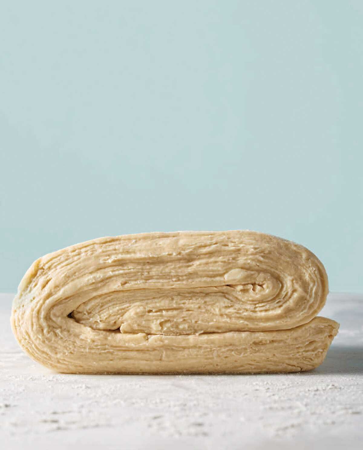 Side angle of croissant dough, with layers of butter and dough visible 