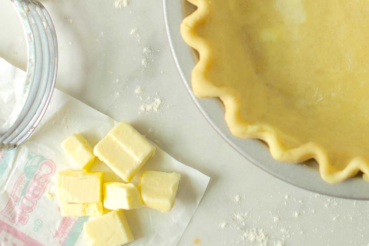 Chopped butter next to pie crust