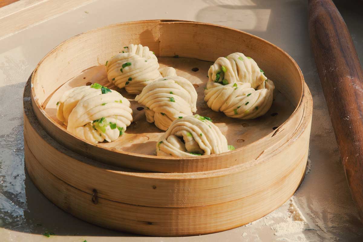 Un-steamed buns in bamboo basket