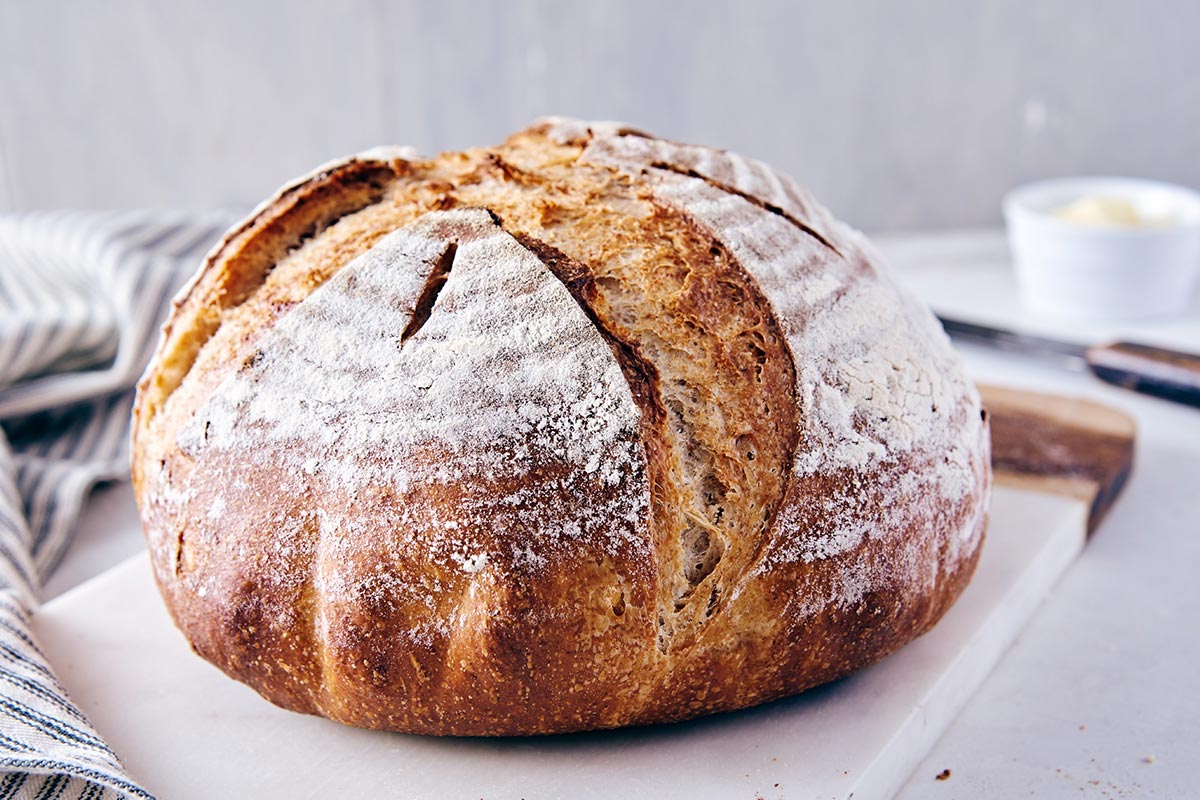 A boule of rye bread with scores on top