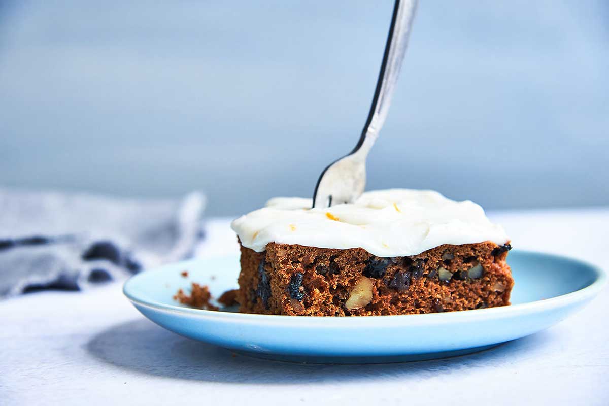 A slice of tomato soup spice cake topped with cream cheese frosting