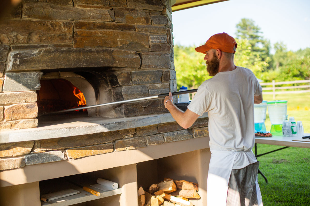Baked loading pizza into wood-fired oven