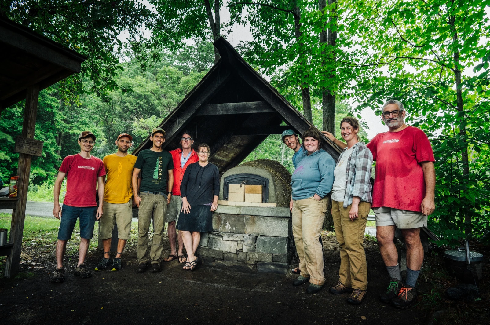 King Arthur volunteers standing around mud oven they built