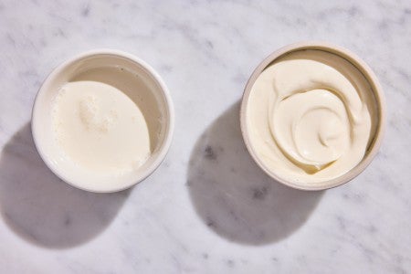 A bowl of leftover heavy cream next to a bowl of creme fraiche