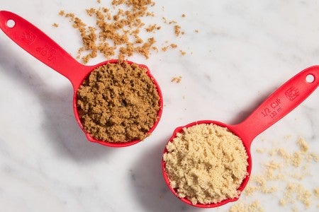 Dry measuring cups full of light and dark brown sugar