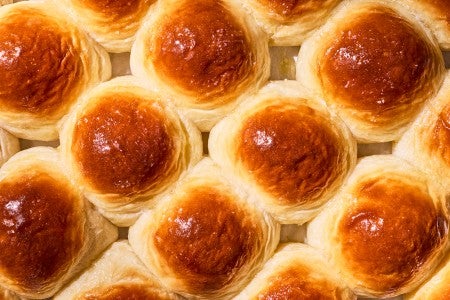 Overhead view of freshly baked dinner rolls on a tray.