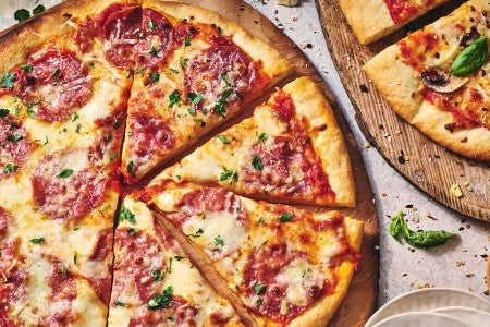 Two pizzas seen from above on wooden pizza peels