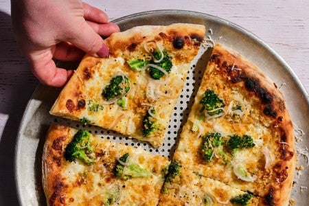 A slice of pizza with broccoli on top 