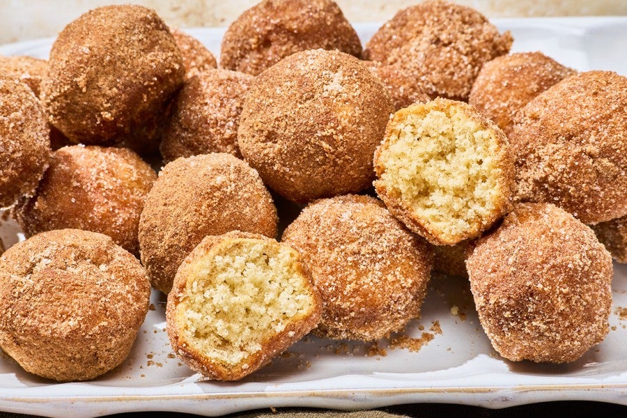 A group of Maple French Toast Mini Muffins with some broken in half to show the interior crumb.