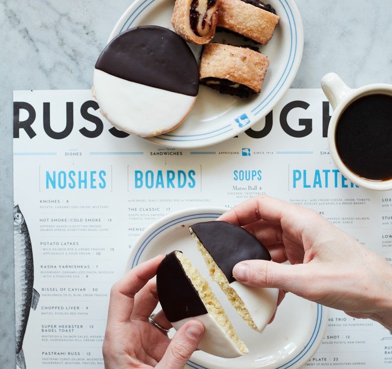 Overhead shot of hands breaking black and white cookie in half