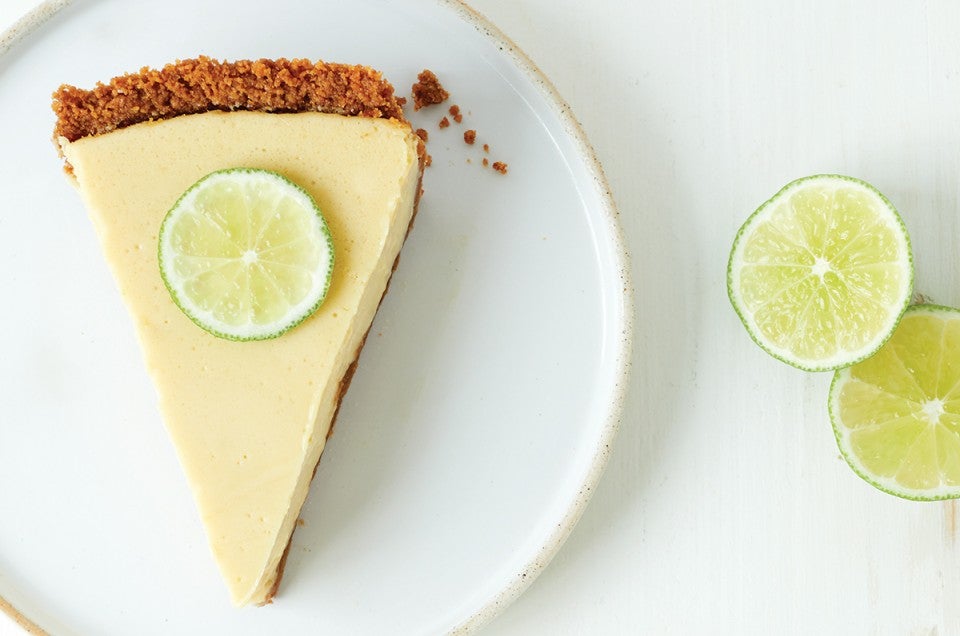 A slice of key lime pie with a graham cracker crust