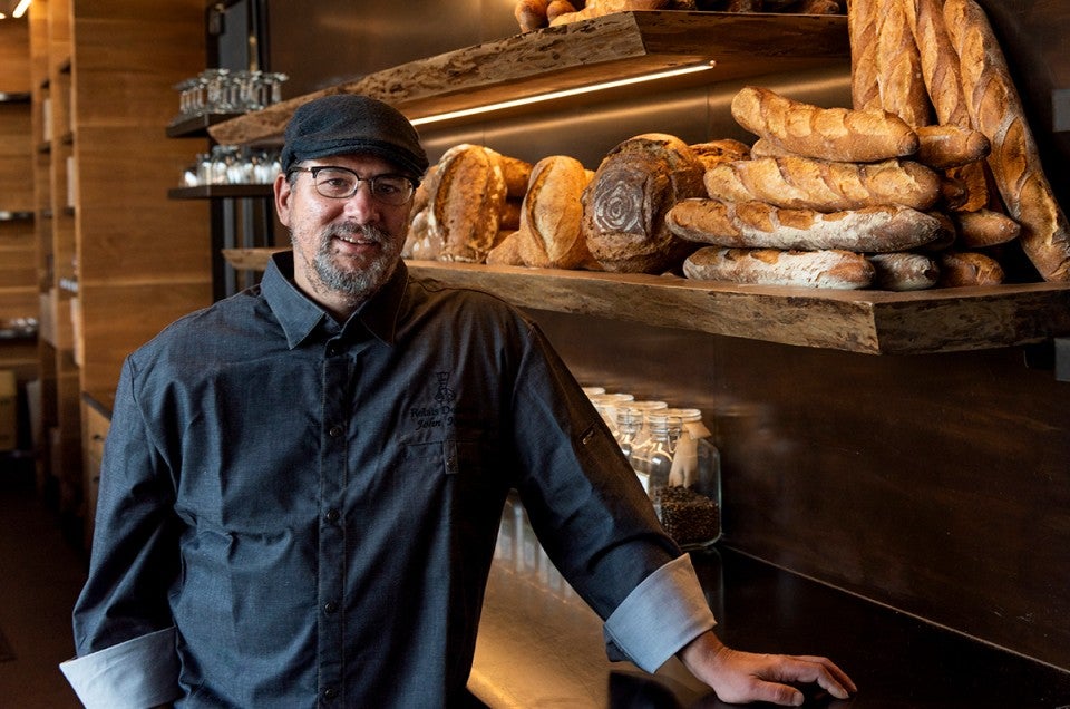 Chef John Kraus in front of shelves of baked goods